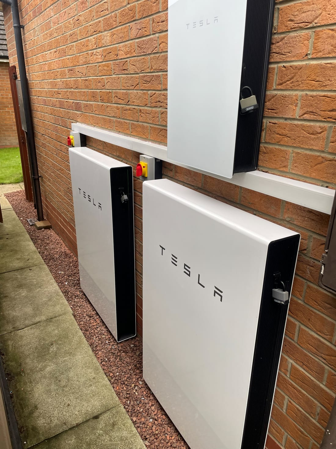 Three Tesla Powerwall batteries installed on an outdoor wall by G Smith Electrical