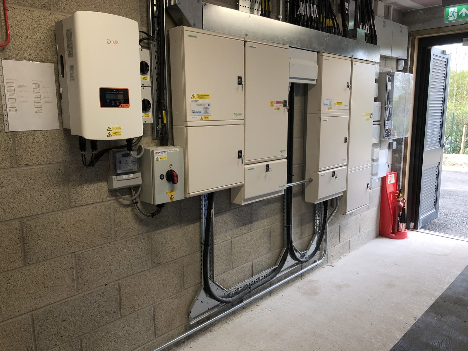 Solar inverter and switchgear mounted on a commercial plant-room wall