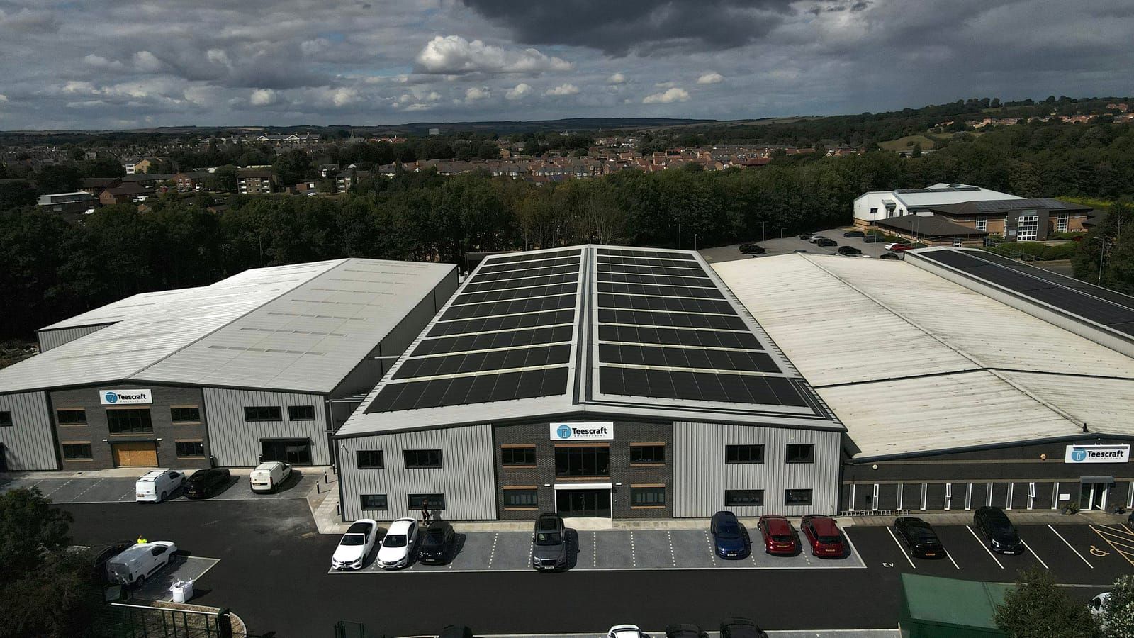 Drone photograph of a completed commercial rooftop solar array on a warehouse